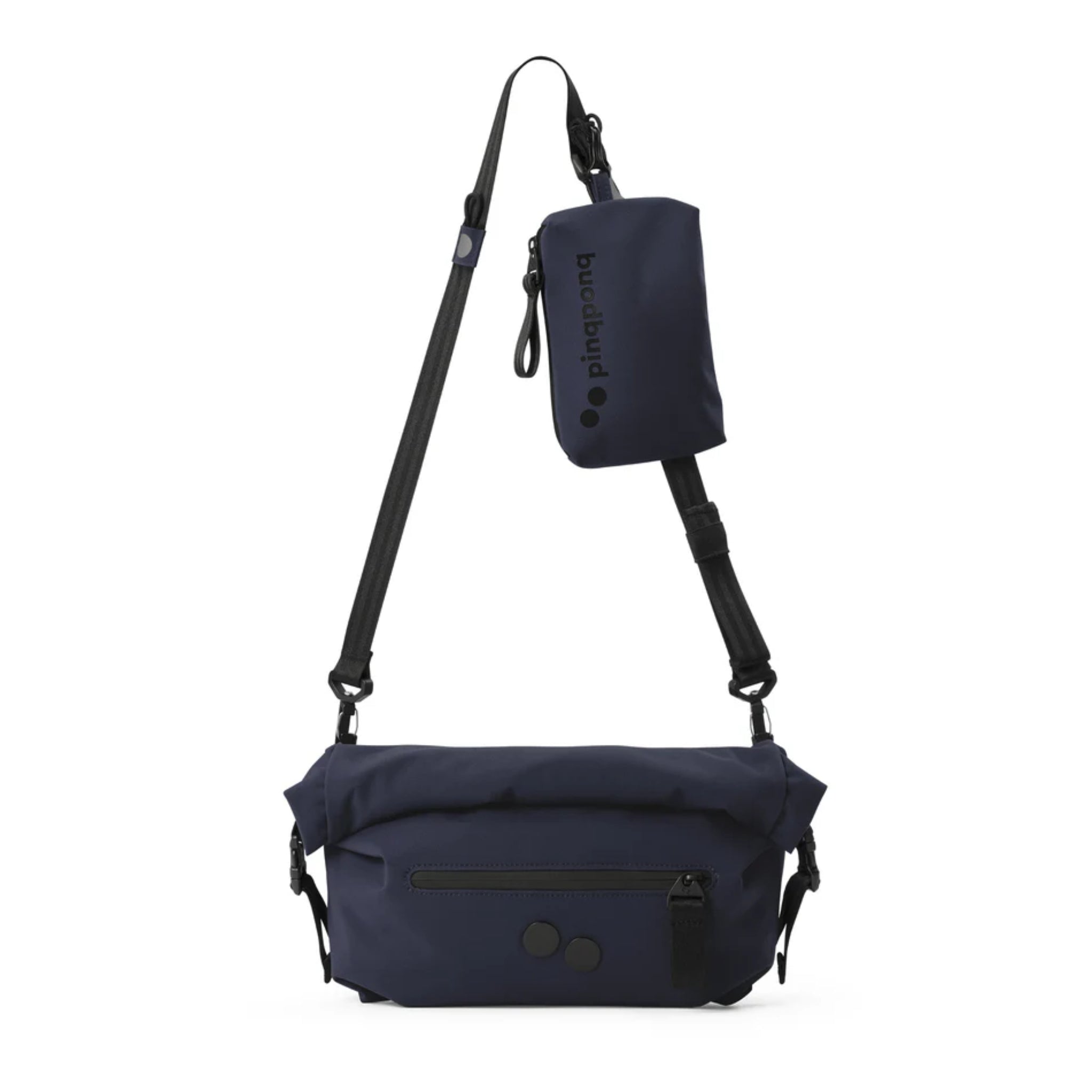 Eine marineblaue Crossbody-Tasche mit einem schwarzen, verstellbaren Riemen und einer kleinen, abnehmbaren Tasche, die am Riemen befestigt ist. Die Tasche hat schwarze Akzente, ein Reißverschlussfach auf der Vorderseite und ein minimalistisches Design.
