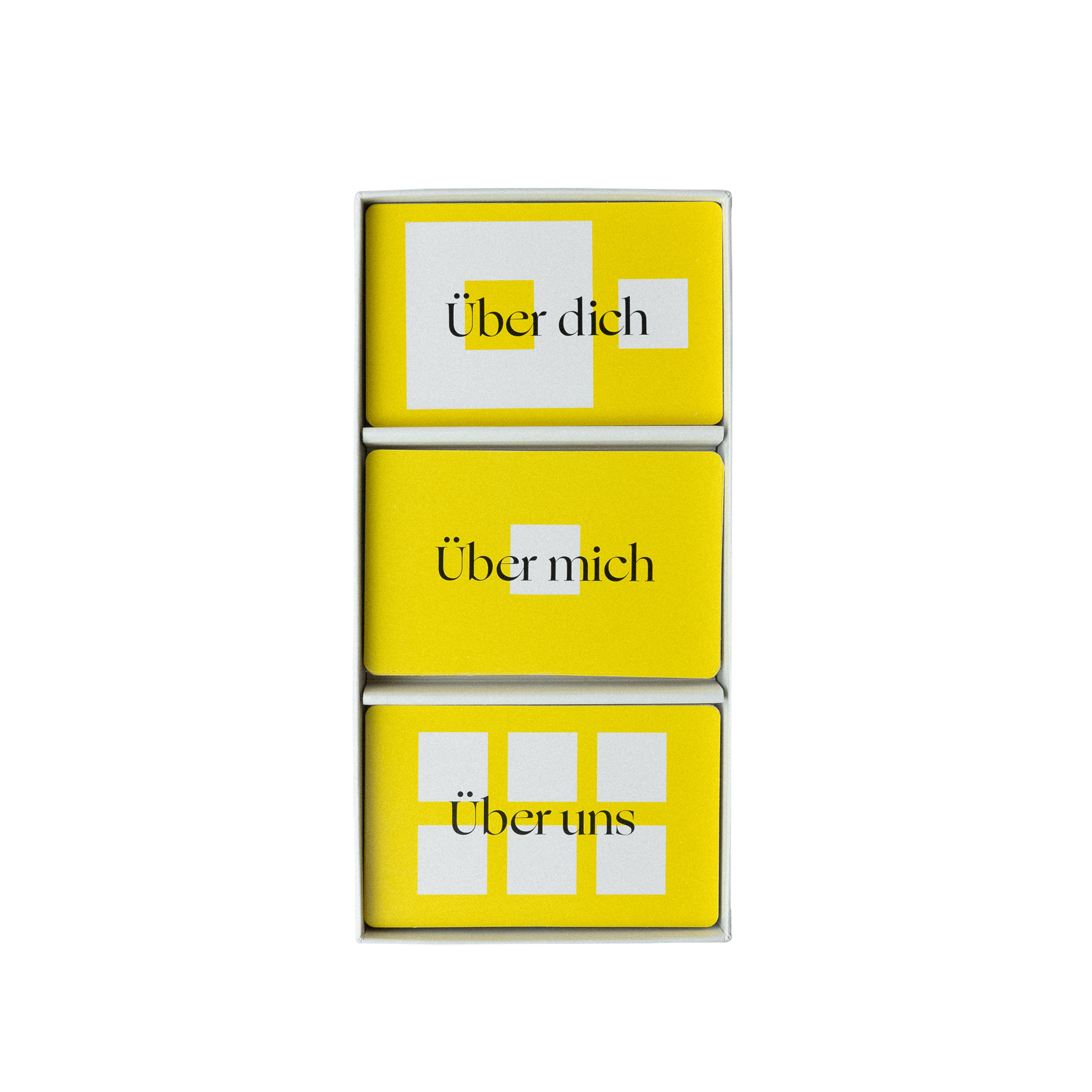 Drei Stapel gelber Karten in einer Schachtel, beschriftet mit "Über dich", "Über mich" und "Über uns".