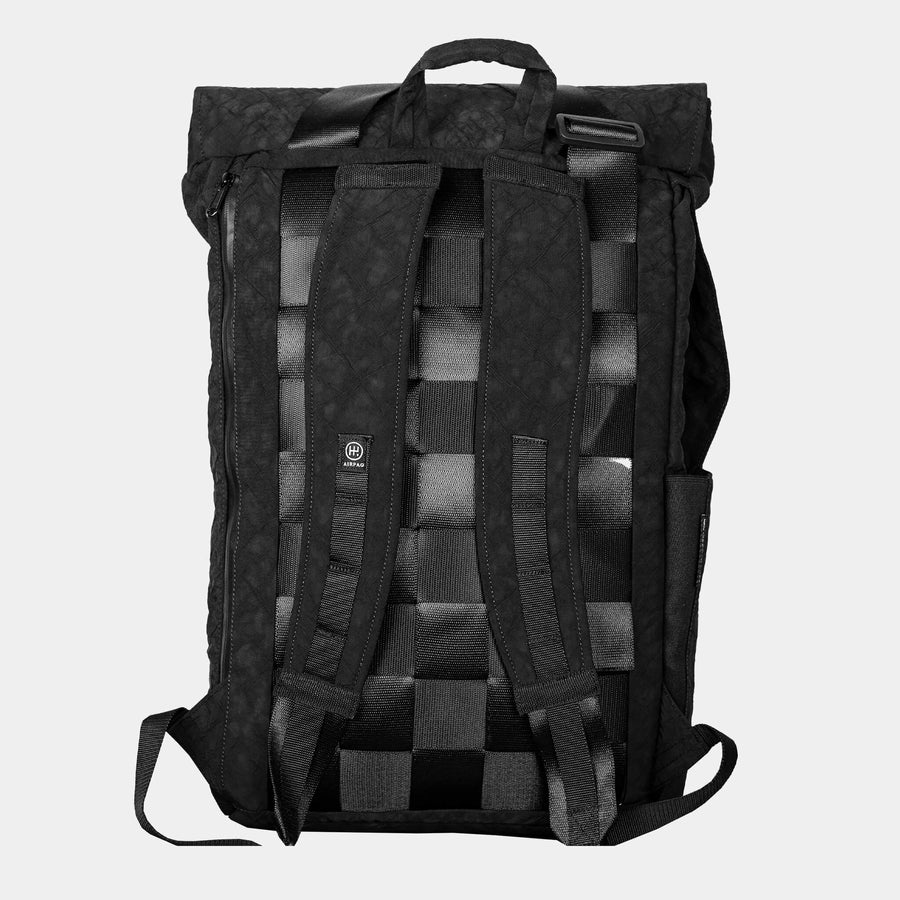 Schwarzer Rucksack von hinten mit gepolsterten Trägern und gewebtem Design auf hellem Hintergrund.
