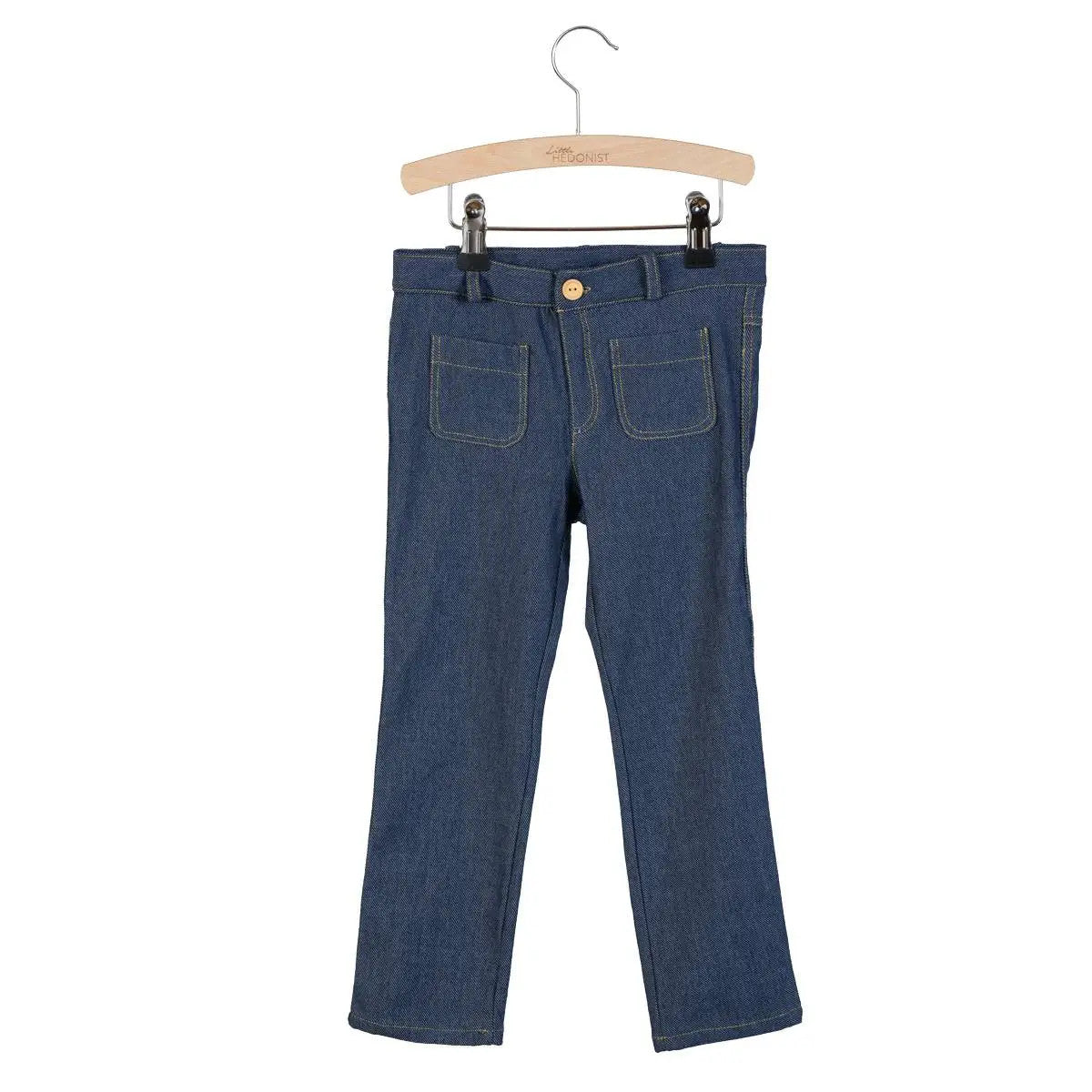 Blaue Denim-Jeans mit aufgesetzten Vordertaschen, gelben Nähten und einem Knopfverschluss, ausgestellt auf einem Holzbügel vor weißem Hintergrund.