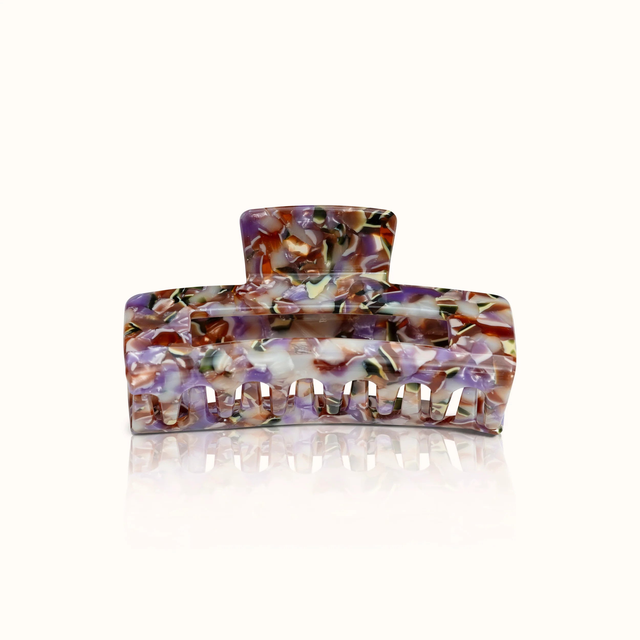 Haarspange mit marmoriertem Muster in Lila-, Braun- und Weißtönen auf hellem Hintergrund.