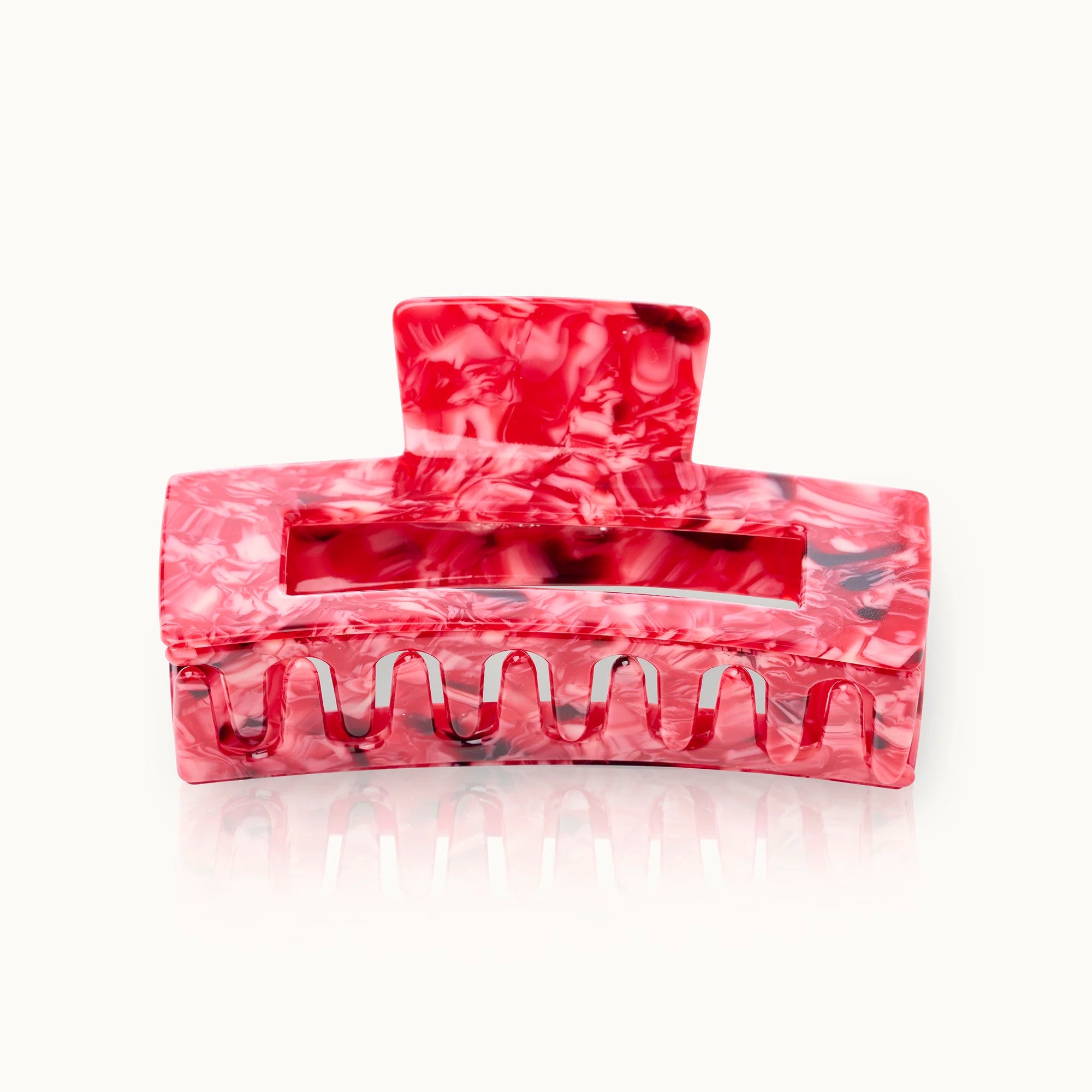 Rote Haarklammer mit marmoriertem Muster auf weißem Hintergrund.