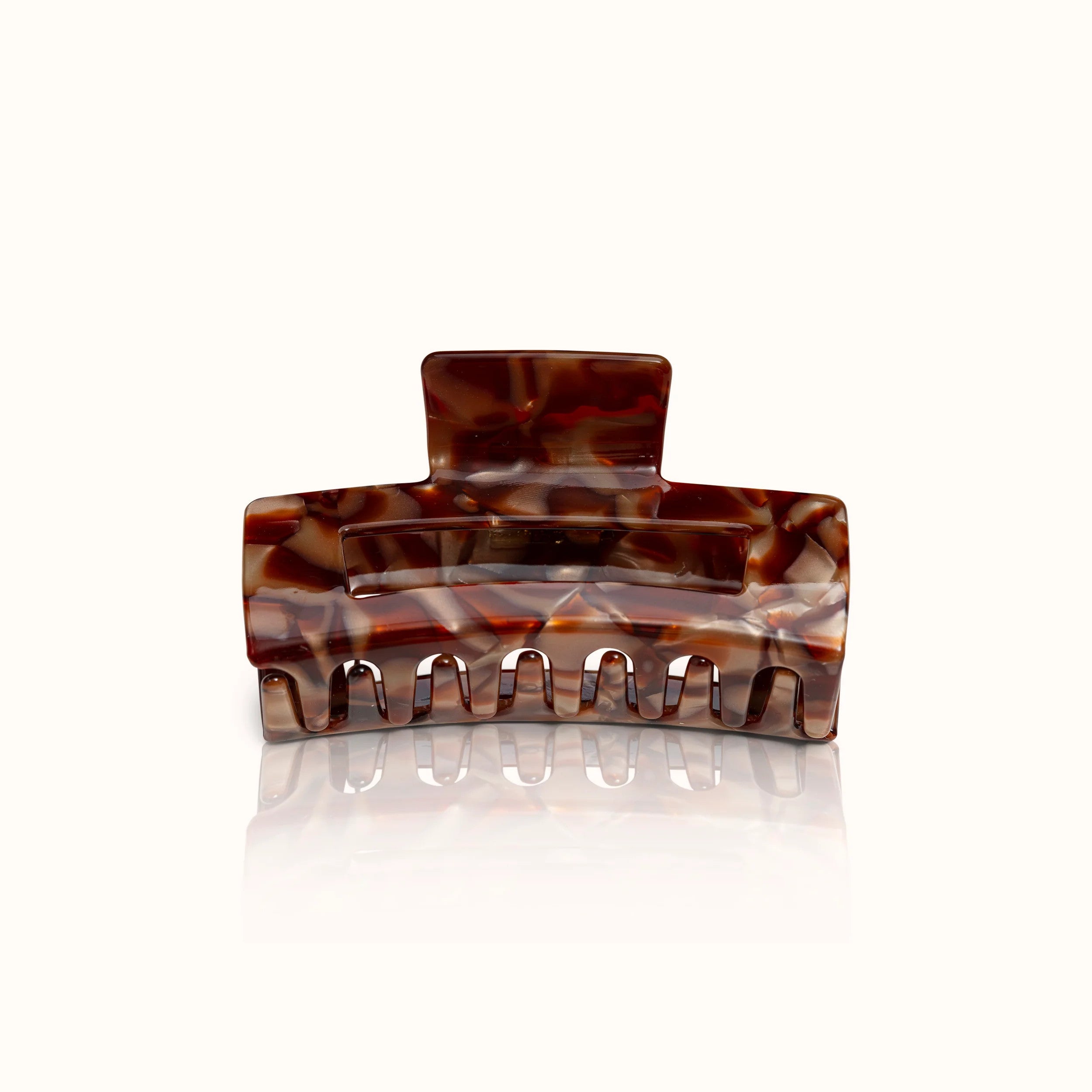 Braune Haarklammer aus Kunststoff mit marmoriertem Muster auf weißem Hintergrund.