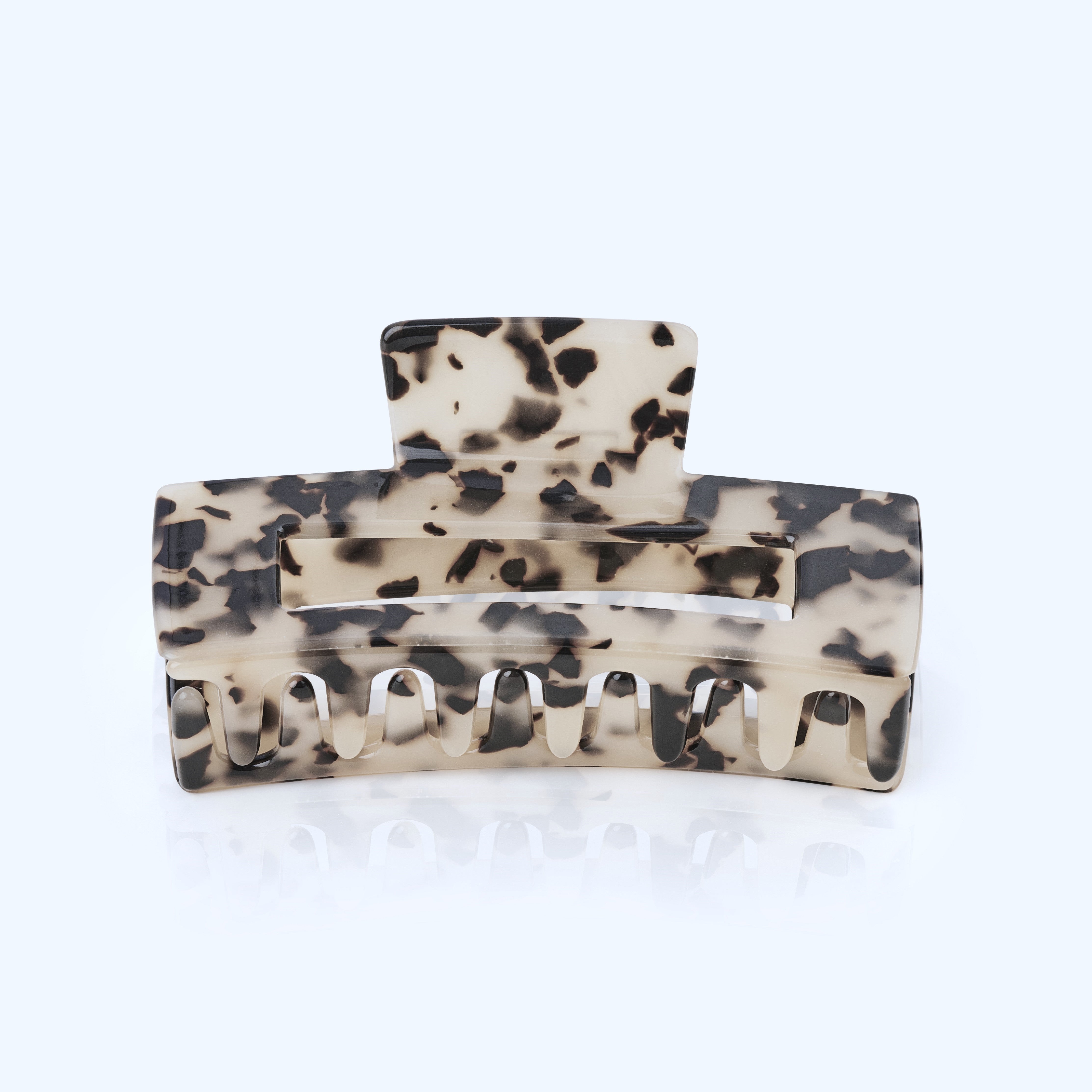 Haarklammer mit schwarz-weißem Leopardenmuster auf hellgrauem Hintergrund.