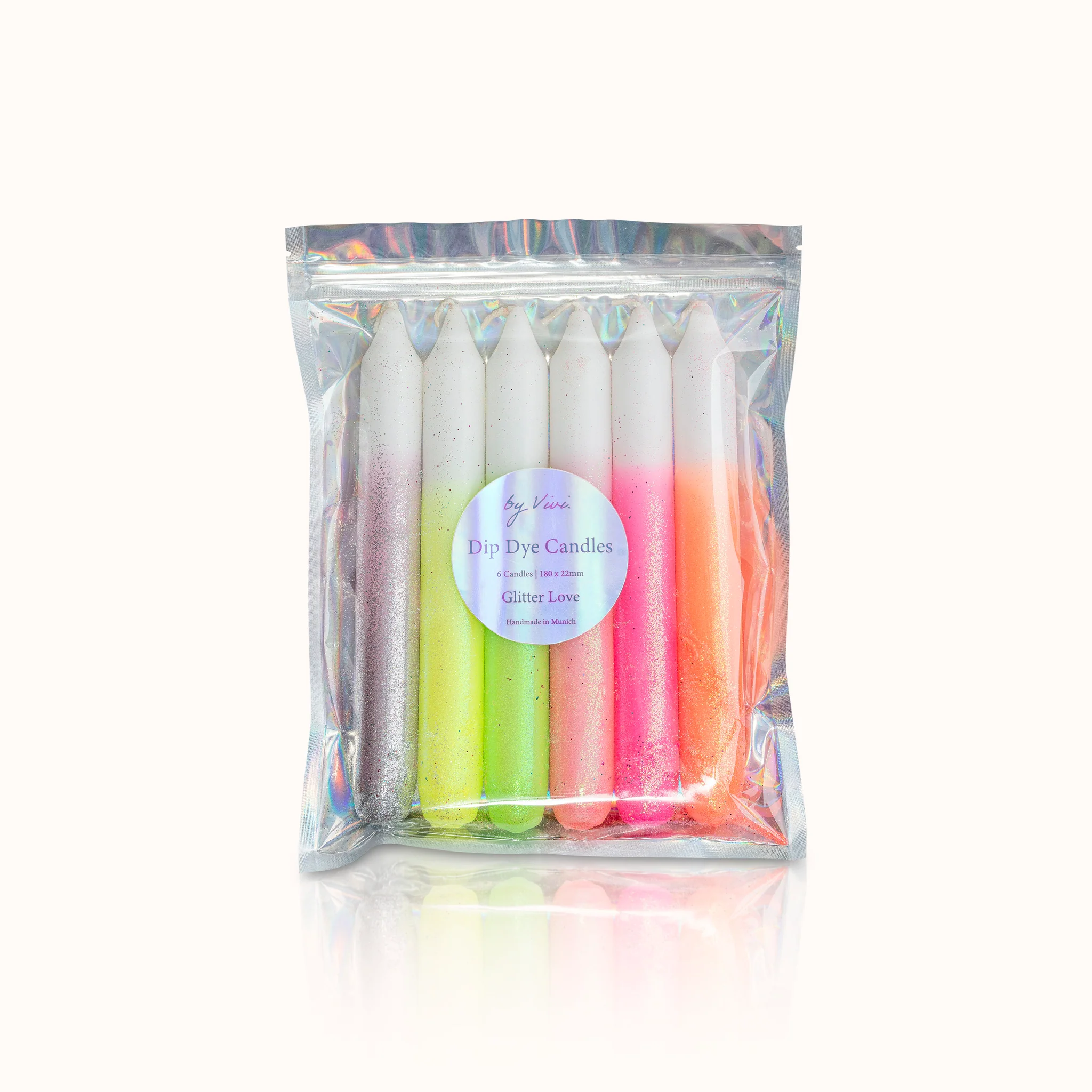 Ein Set bunter Dip-Dye-Kerzen in Plastikverpackung, jede mit glitzernden Farbverläufen.