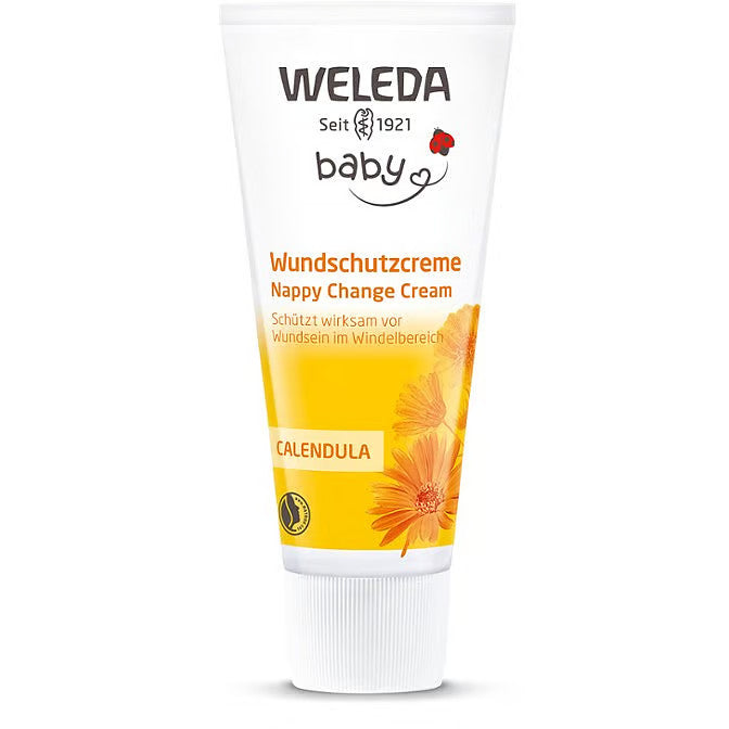 Eine weiß-gelbe Tube der Weleda Wickelcreme mit Ringelblume mit orangefarbenen Ringelblumenblüten und deutschem und englischem Text auf der Verpackung.