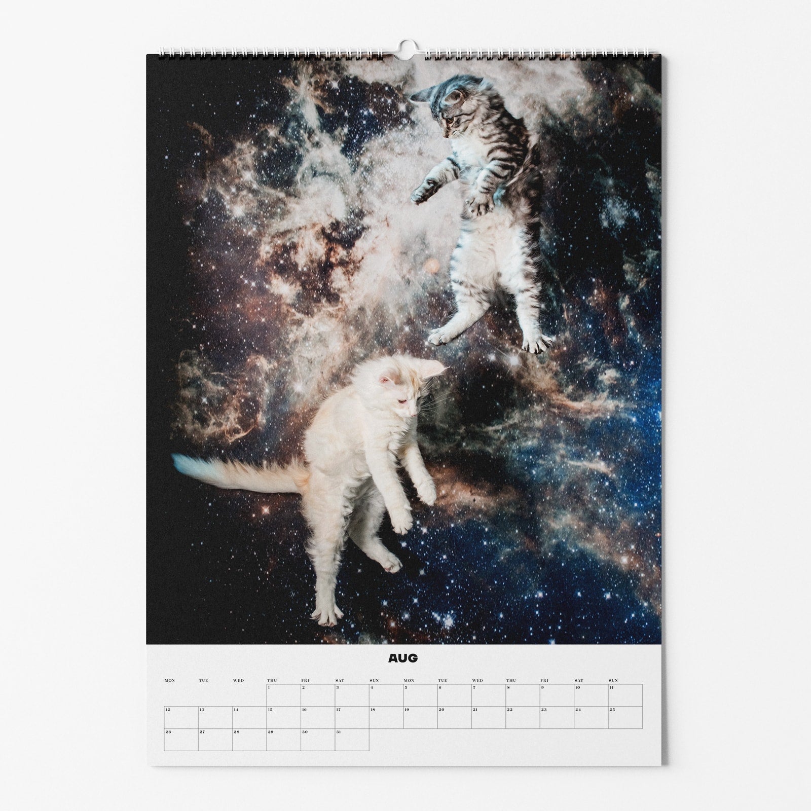 Kalenderseite für August mit schwebenden Katzen im Weltall vor einem Hintergrund aus Sternen und Galaxien.