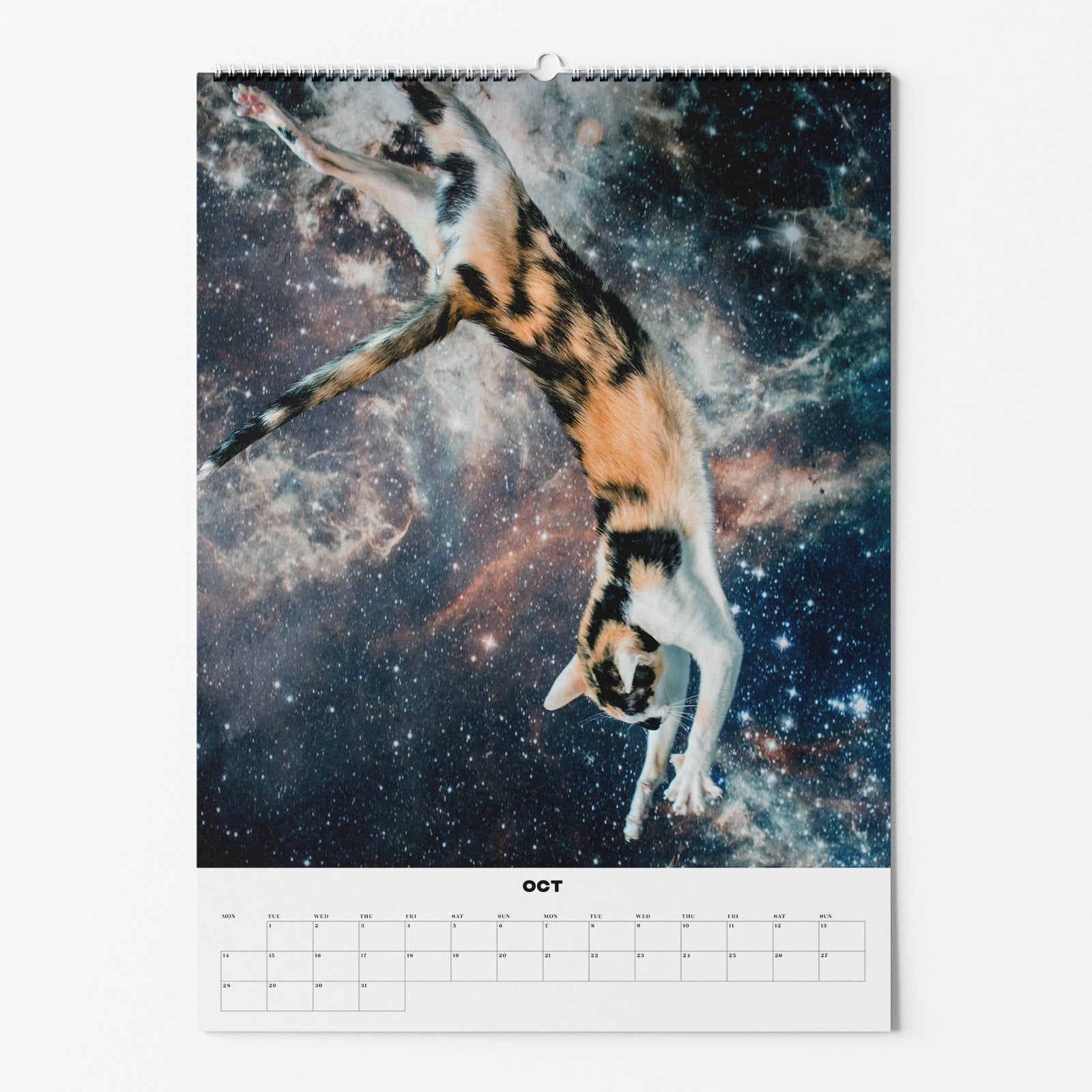 Kalenderblatt für Oktober zeigt eine springende Katze vor einem Hintergrund aus Galaxien und Sternen im Weltraum.