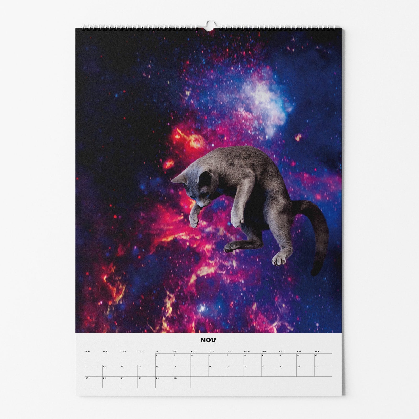 Kalenderblatt für November mit einer schwebenden Katze vor einem bunten, nebligen Weltraumhintergrund.
