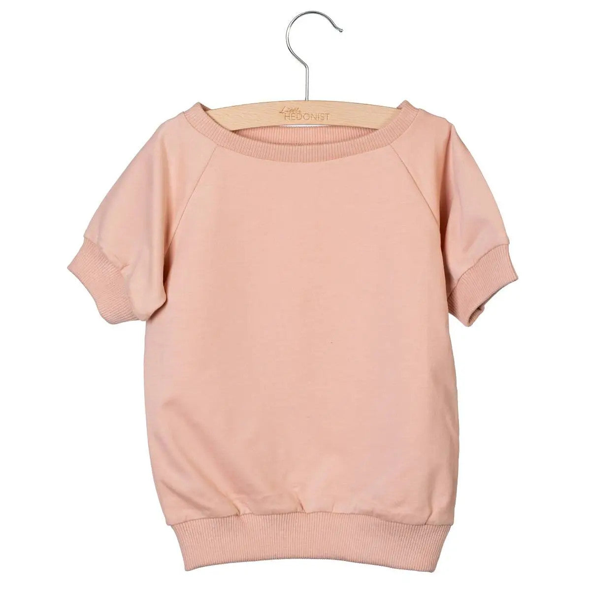 Ein hellrosa, kurzärmeliges Sweatshirt für Kleinkinder mit gerippten Manschetten, Kragen und Bund, das auf einem Holzbügel vor einem schlichten weißen Hintergrund ausgestellt ist.