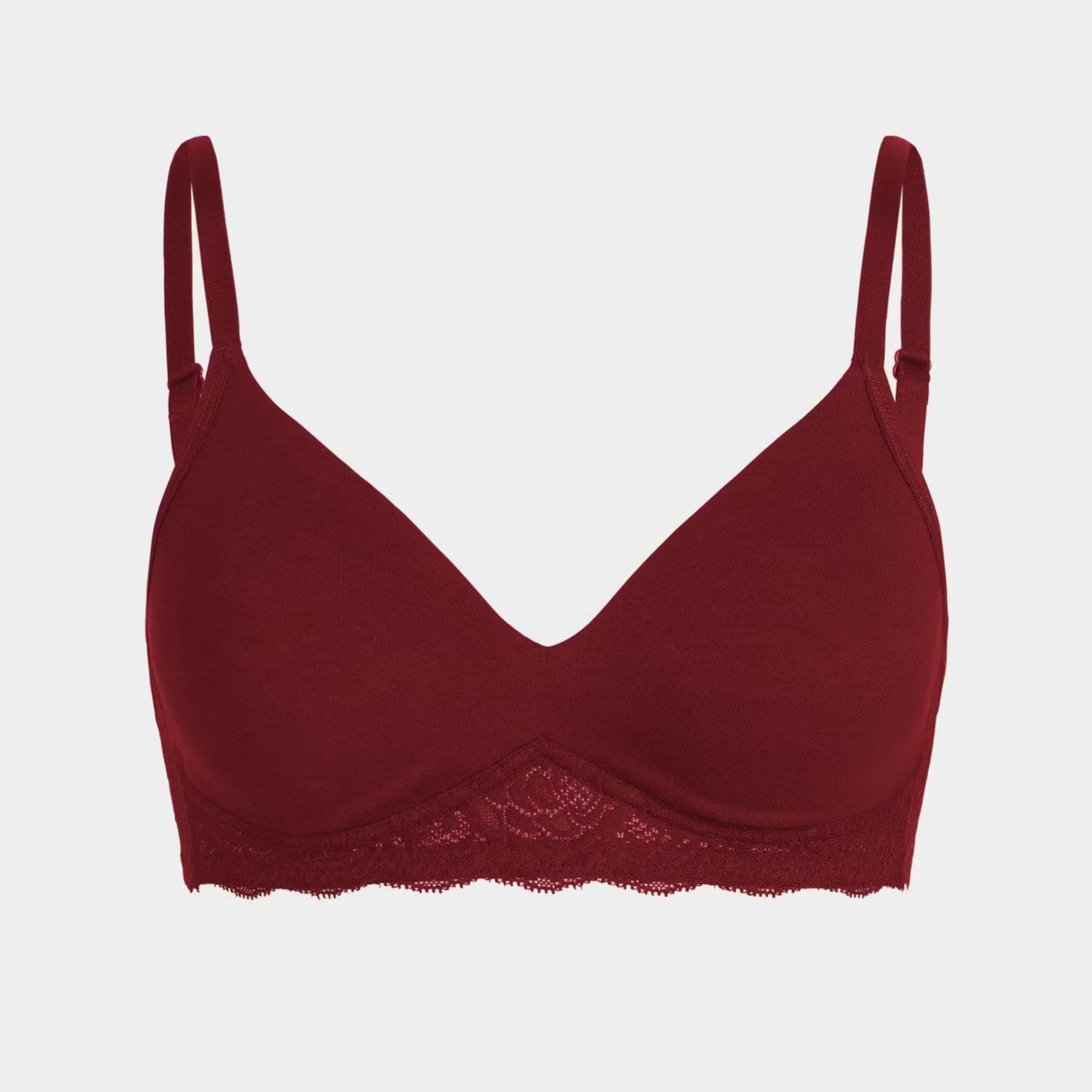 Roter BH mit schmalen Trägern und Spitzenbesatz an der Unterseite vor weißem Hintergrund.