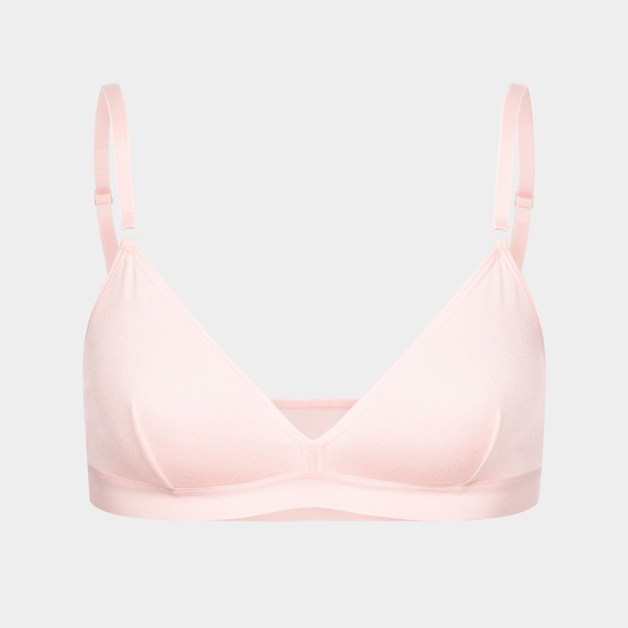 Helles rosa Bralette mit dünnen Trägern und V-Ausschnitt, vor neutralem Hintergrund.