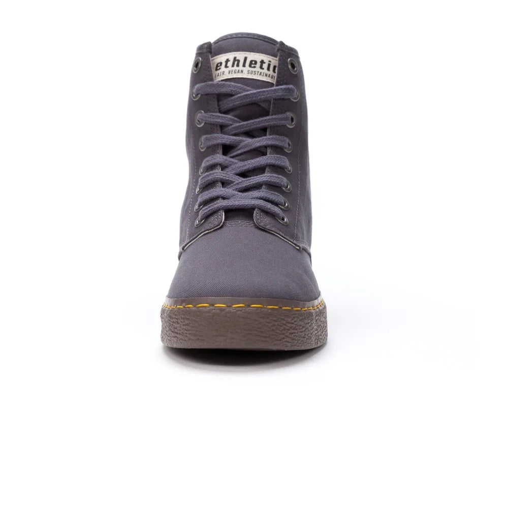 Ein grauer High-Top-Sneaker mit Schnürsenkeln, von vorne gesehen, mit einer braunen strukturierten Sohle und einem weißen Etikett auf der Zunge mit der Aufschrift Athletic. Der Schuh ist vor einem weißen Hintergrund fotografiert.