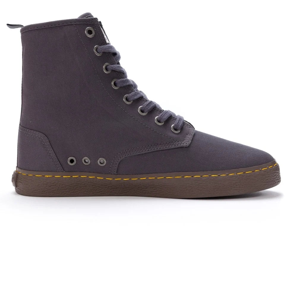 Ein High-Top-Stiefel im Sneaker-Stil aus dunkelgrauem Canvas mit passenden Schnürsenkeln, einer braunen Gummisohle, Metallösen und gelben Nähten über der Sohle, von der Seite betrachtet.