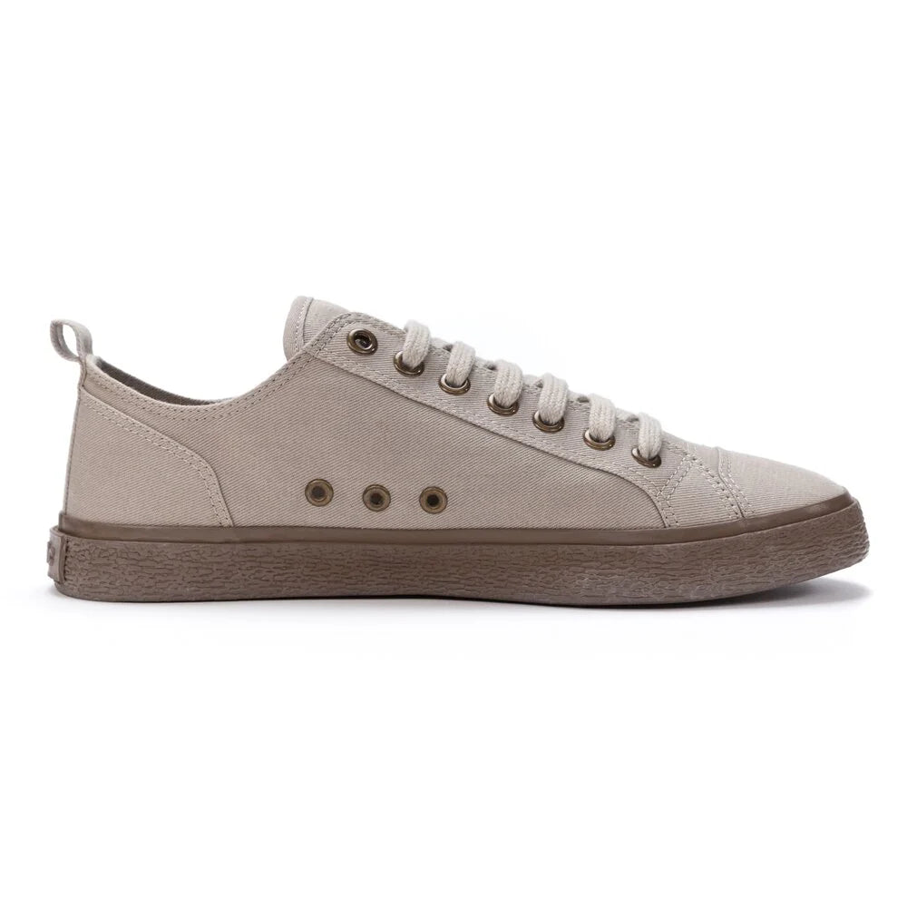 Ein beiger Canvas-Sneaker mit braunen Ösen und einer braunen Gummisohle, von der Seite vor weißem Hintergrund gezeigt. Der Schuh hat eine Schnürung und ein Low-Top-Profil.
