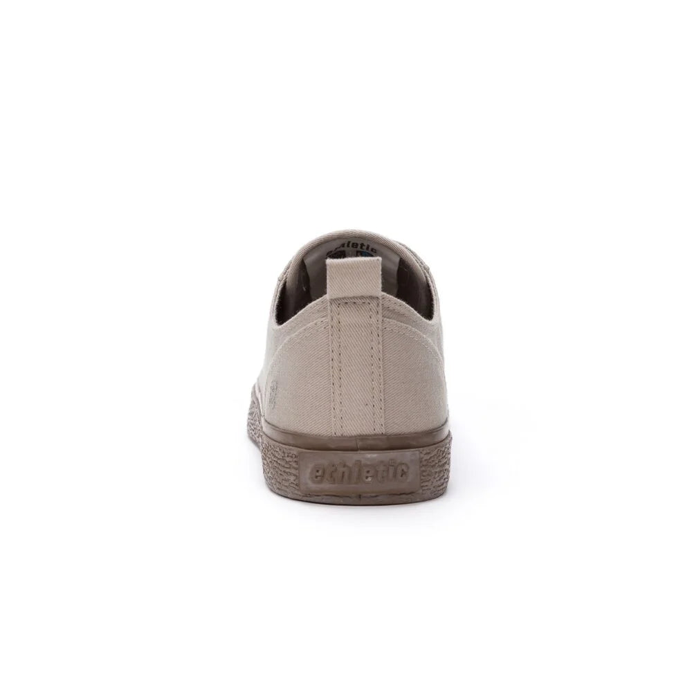 Beigefarbener Sneaker mit brauner, strukturierter Sohle und einer Zuglasche an der Ferse; der Markenname Ethletic ist auf der Sohle eingeprägt.