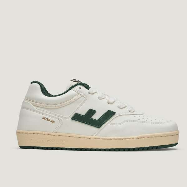Weißer Retro-Sneaker mit grünen Akzenten und cremefarbener Sohle, Seitenansicht.