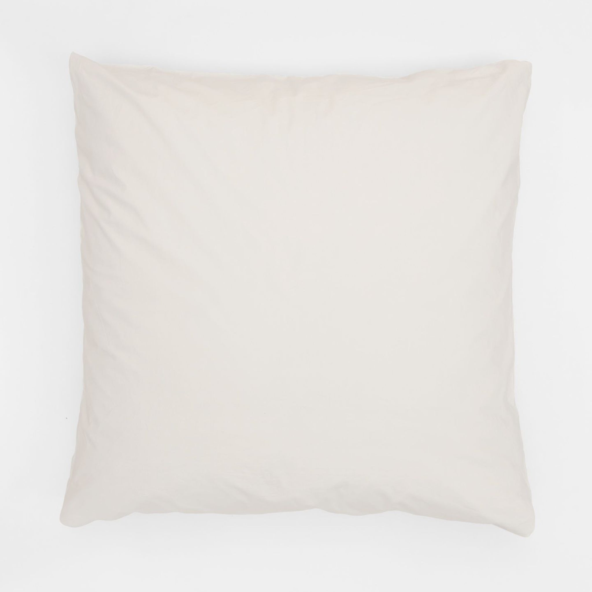 Ein schlichtes, cremefarbenes Kissen auf einem weißen Hintergrund.