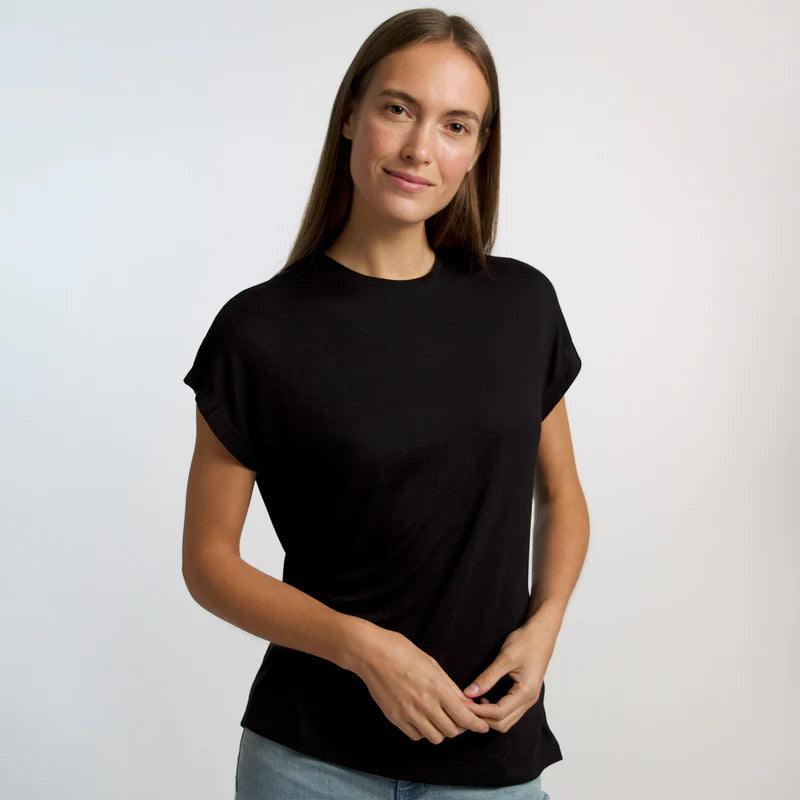 Eine Person mit langen braunen Haaren trägt ein schwarzes T-Shirt und lächelt in die Kamera.