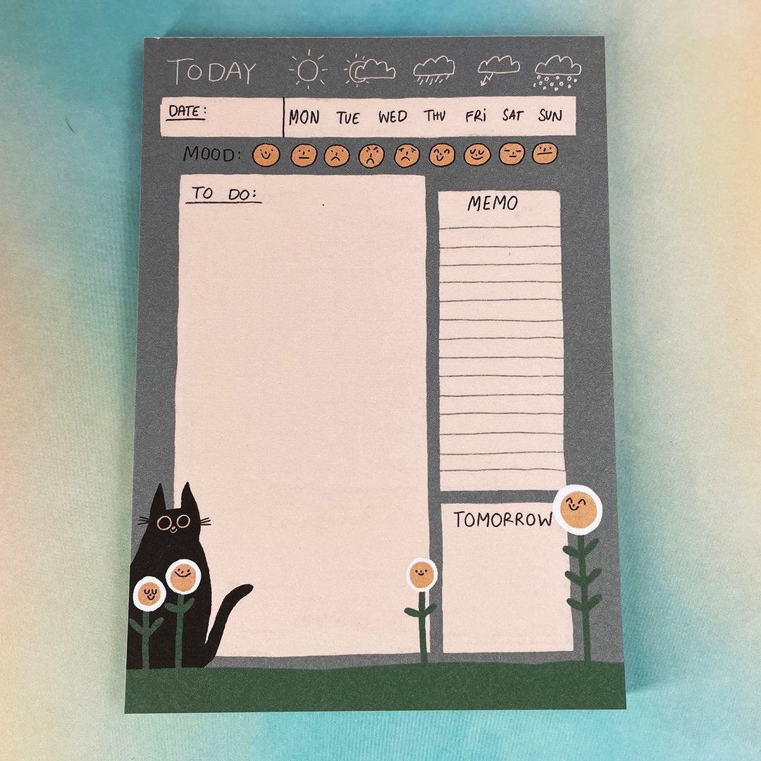 Planer mit Wochentagen, Wetter, Stimmungssymbolen, To-Do-Liste, Memo-Feld und schwarzer Katze mit Blumen.