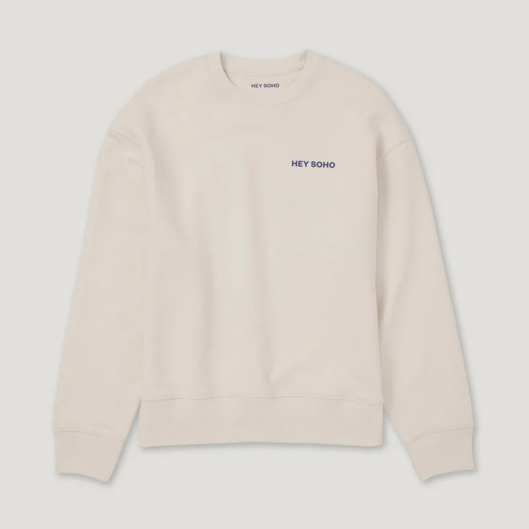 Beiger Pullover mit gesticktem "HEY SOHO" Schriftzug in Dunkelblau auf der Brust, vor weißem Hintergrund.