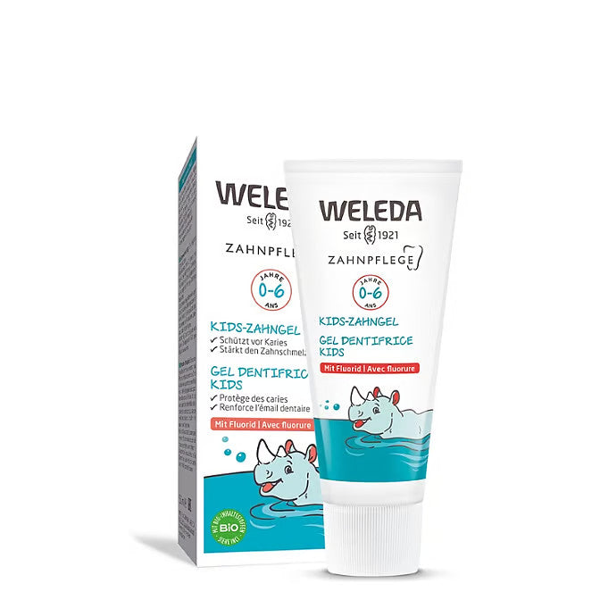 Eine Schachtel und eine Tube Weleda Kids Zahngel mit einem Cartoon-Nilpferd im Wasser. Das Produkt ist für die Altersgruppe 0-6 Jahre und enthält Fluorid. Die Verpackung hat weiße und blaugrüne Akzente.