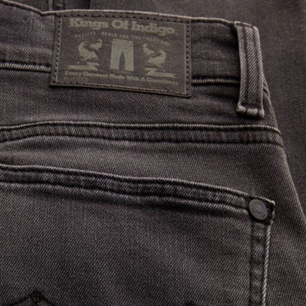 Nahaufnahme einer grauen Jeans mit einem Etikett der Marke "Kings Of Indigo" am hinteren Bund.
