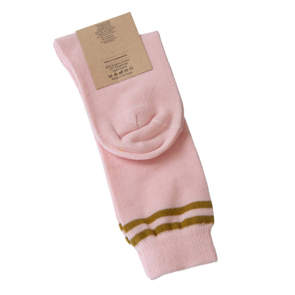 Ein Paar gefaltete hellrosa Socken mit zwei olivgrünen Streifen in der Nähe des oberen Randes, die mit einem braunen Kartonetikett versehen sind.