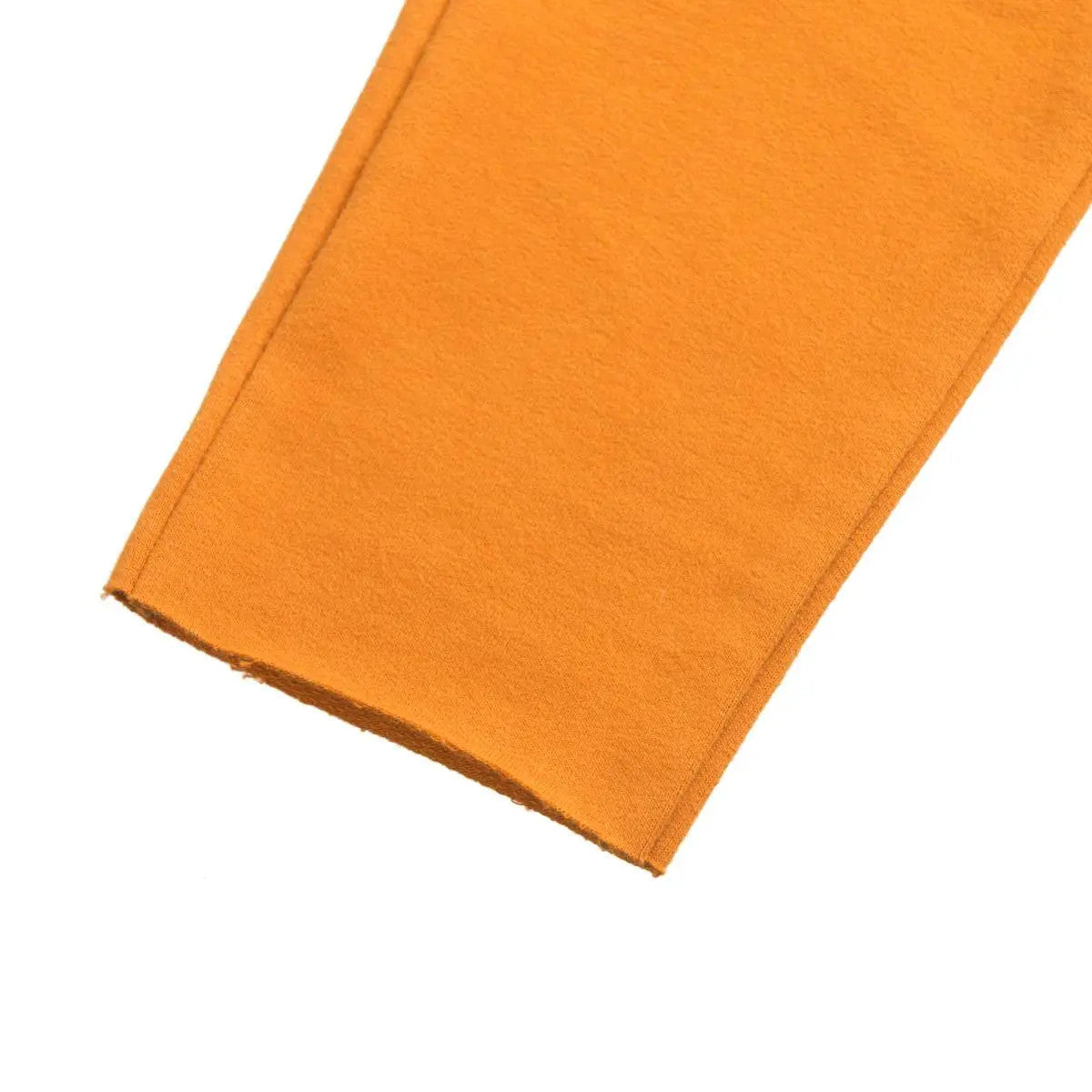 Nahaufnahme des Saums eines orangefarbenen Hosenbeins, die eine saubere, einfache Naht ohne sichtbare Nahtdetails zeigt.