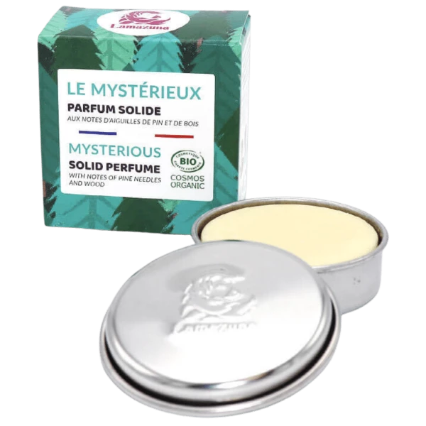 Runde Metallbox mit festem Parfüm und dazugehöriger Verpackung mit grünem Design und der Aufschrift "Le Mystérieux".