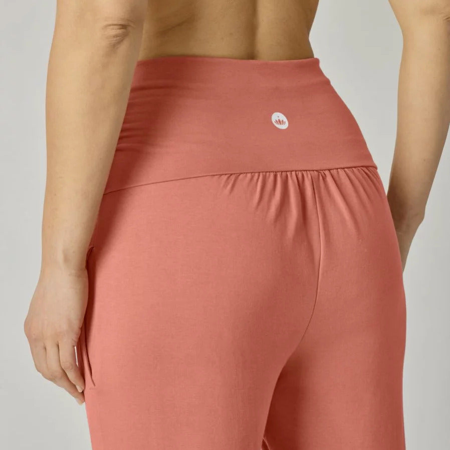 Person von hinten in rosa Leggings mit einem kleinen Logo auf der Rückseite.