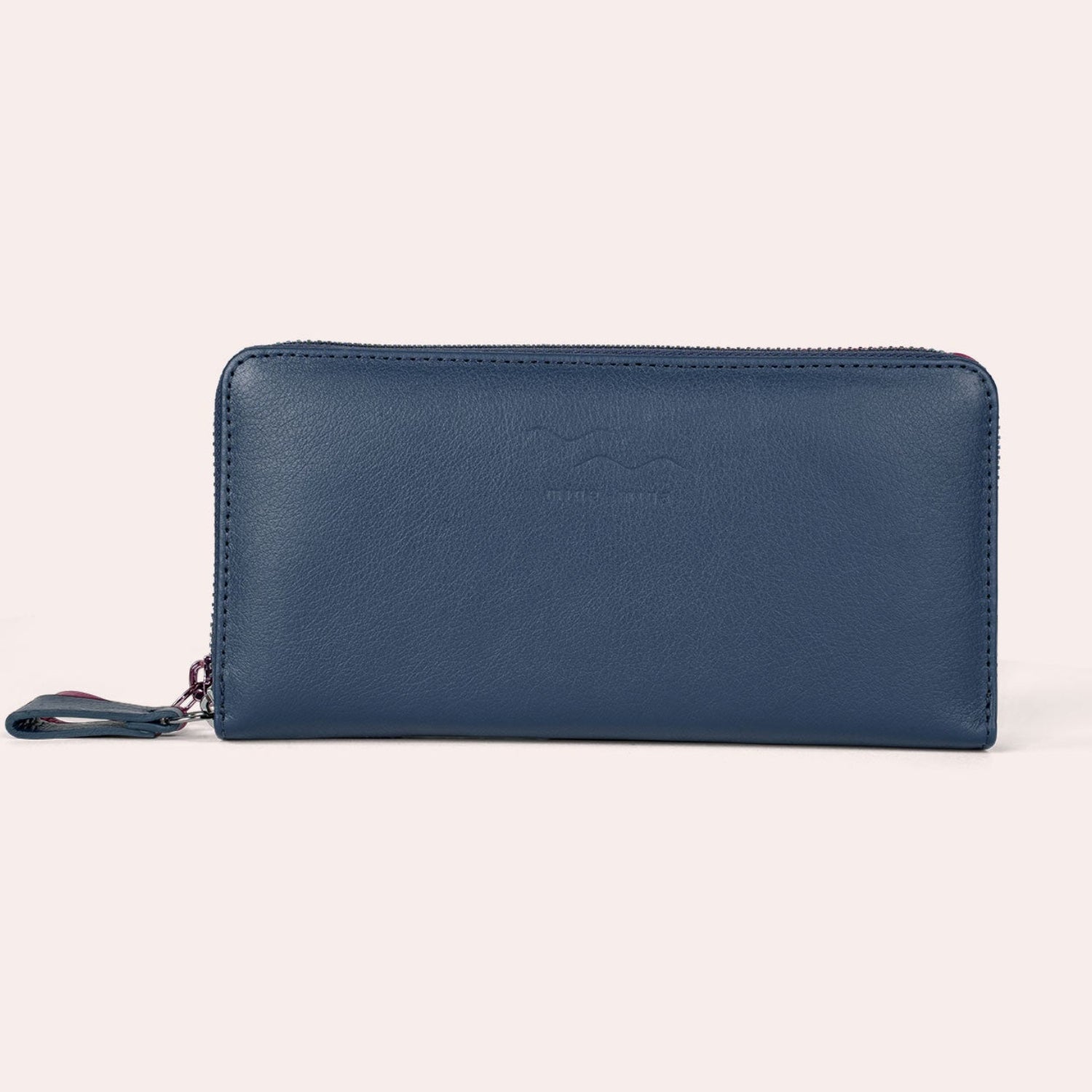 Ein blaues Lederportemonnaie mit Reißverschluss und einfachem Design, dargestellt vor einem schlichten hellen Hintergrund. Der Reißverschluss ist auf der linken Seite sichtbar.