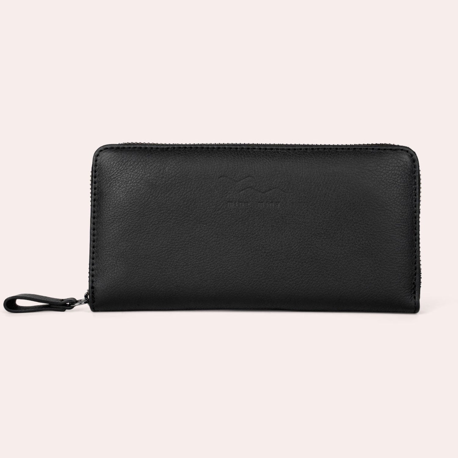 Ein schwarzes Lederportemonnaie mit Reißverschluss und Handschlaufe, das aufrecht vor einem schlichten hellen Hintergrund steht.