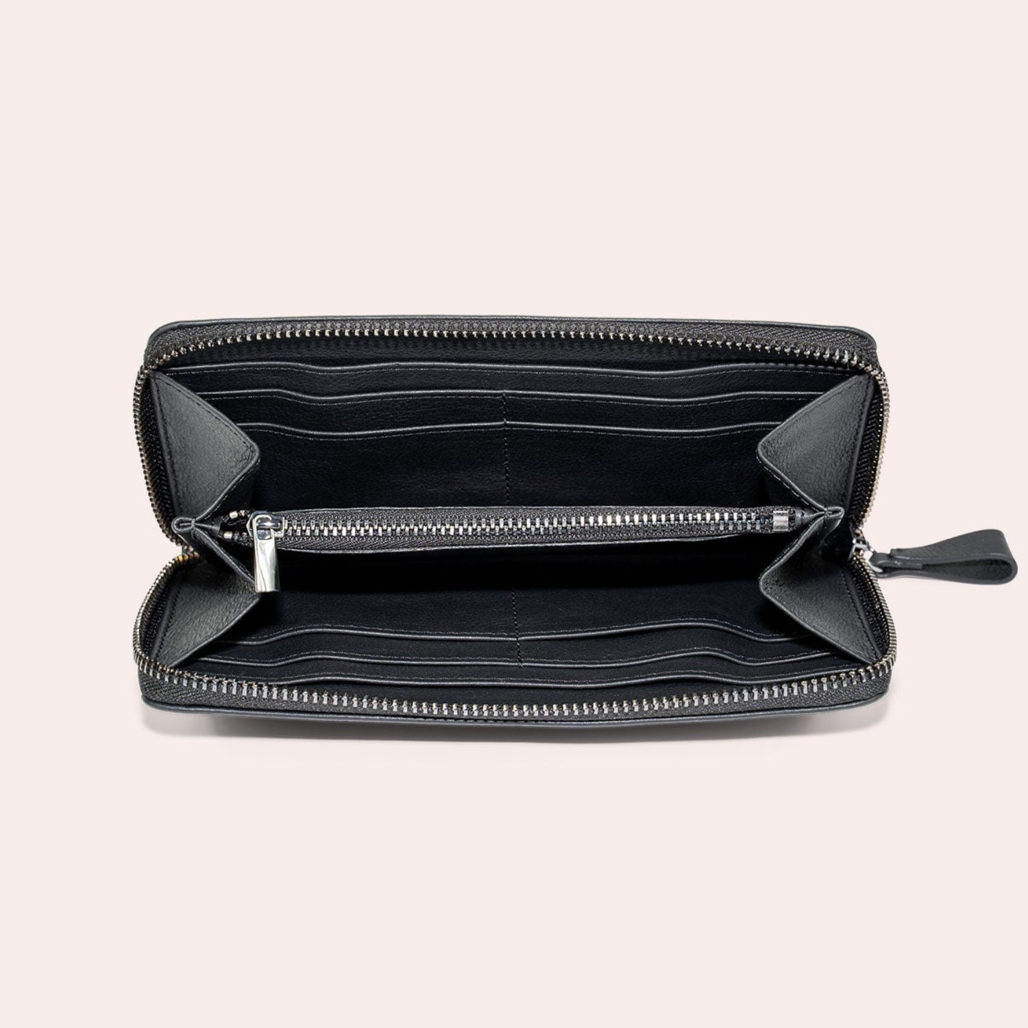 Ein offenes schwarzes Portemonnaie mit Reißverschluss auf hellem Hintergrund, das mehrere Kartenfächer, ein zentrales Münzfach mit Reißverschluss und geräumige Fächer aufweist.