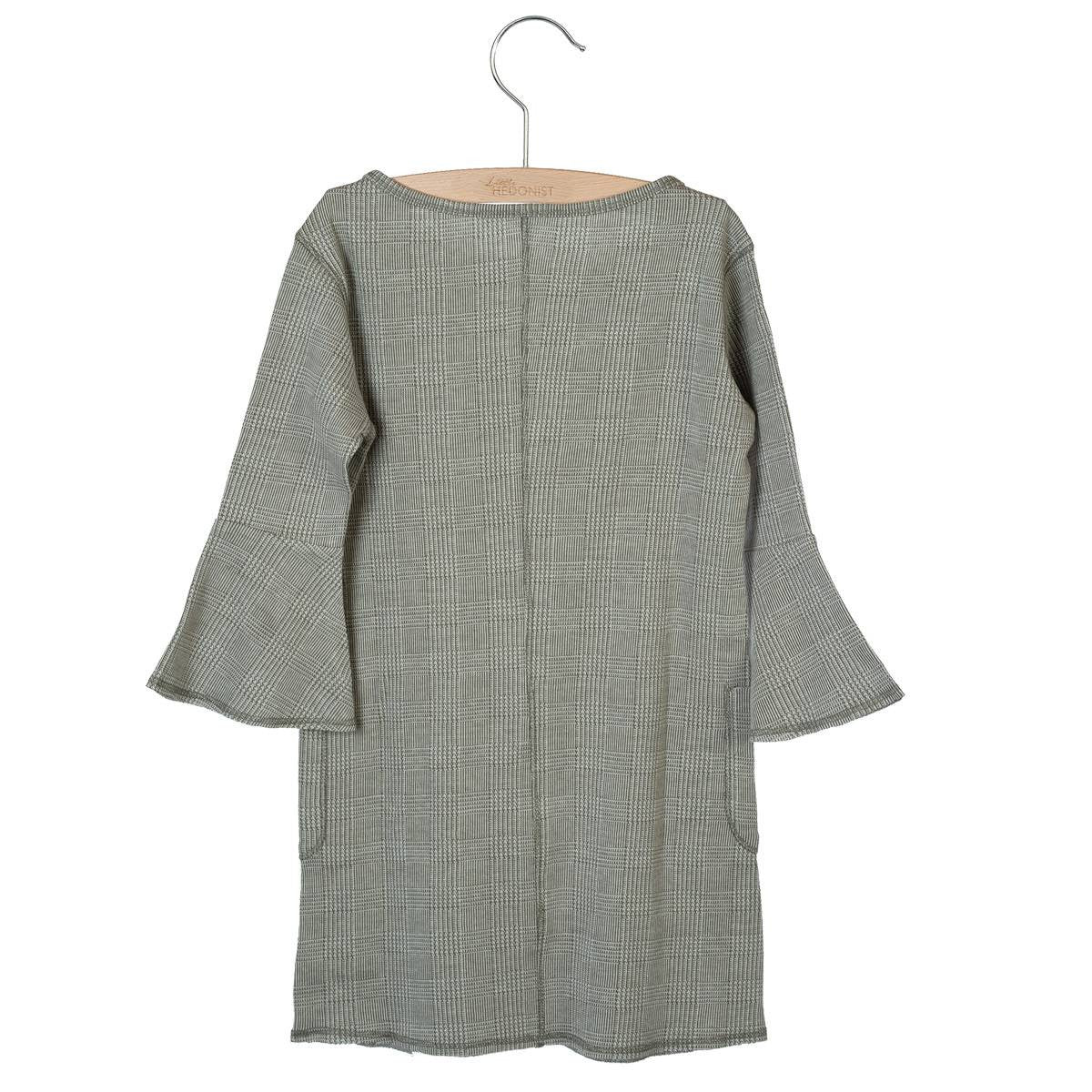 Langärmeliges Kinderkleid mit dezentem Karomuster in Grautönen, mit ausgestellten Ärmeln und einer einfachen, geraden Silhouette, ausgestellt auf einem Holzbügel vor weißem Hintergrund.