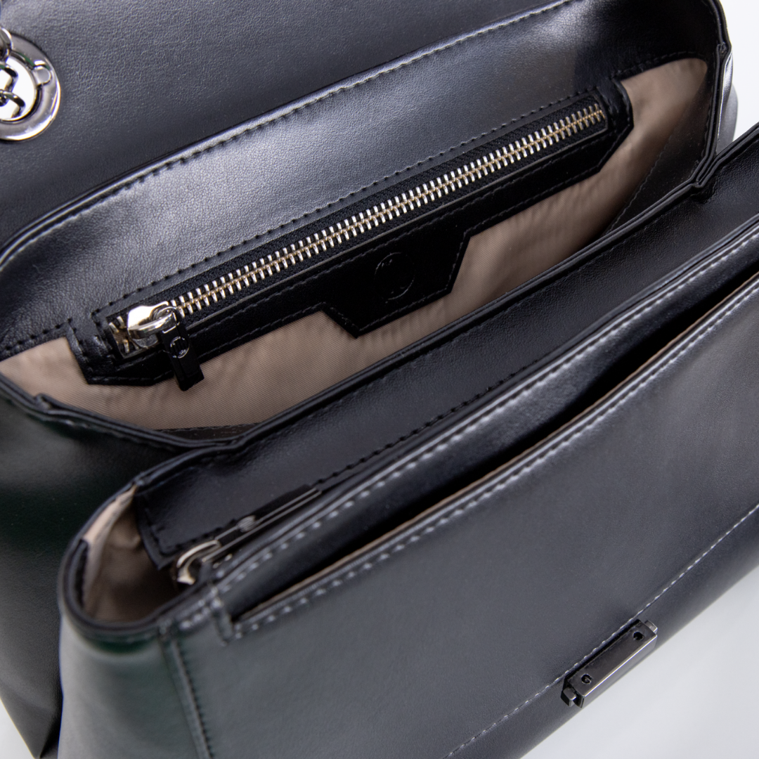 Schwarze Ledertasche mit mehreren Fächern und einem Reißverschluss-Innenfach, von oben fotografiert.