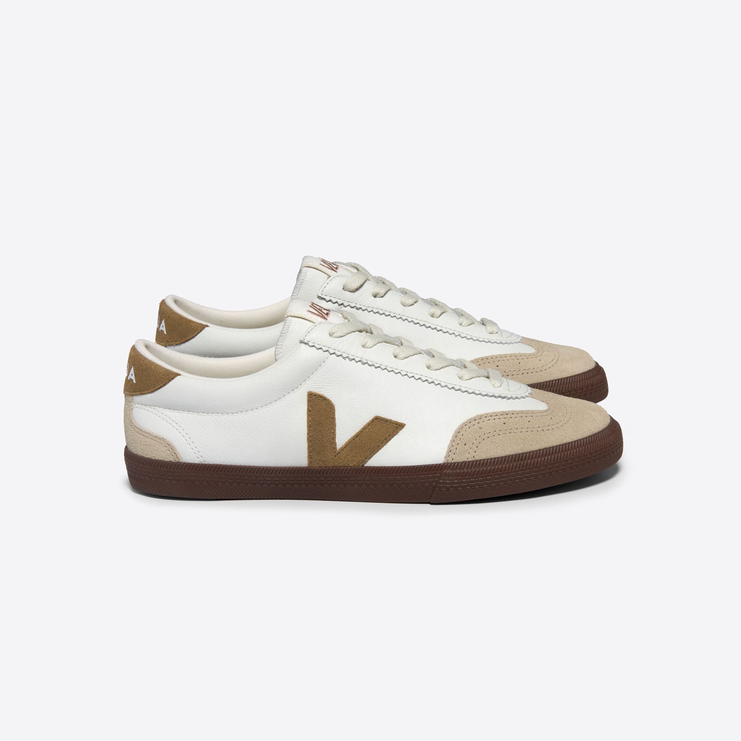 Weiße Sneaker mit braunen Details und einer dunkelbraunen Sohle auf weißem Hintergrund.