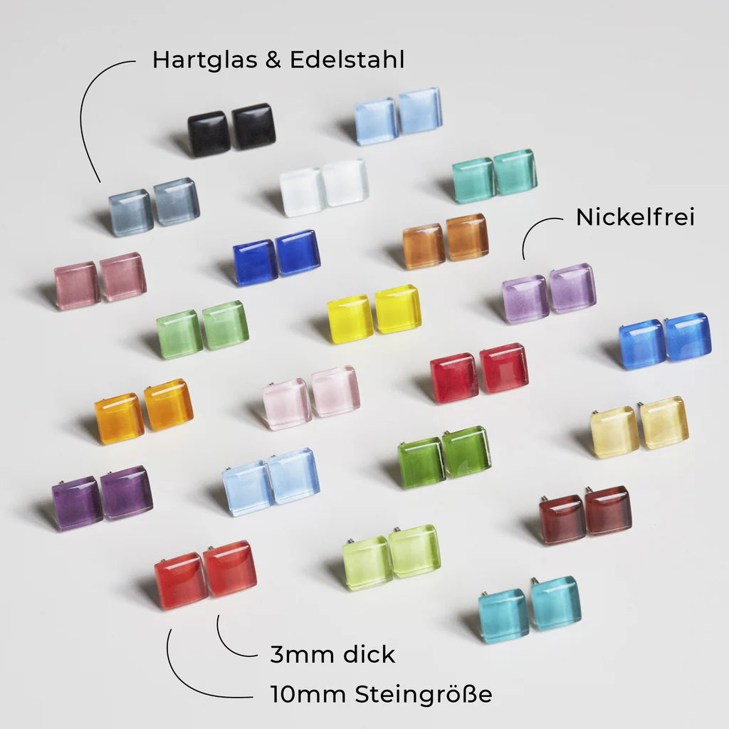 Eine Auswahl von quadratischen Ohrsteckern in verschiedenen Farben, die in Reihen auf weißem Hintergrund angeordnet sind, beschriftet mit "Hartglas & Edelstahl", "Nickelfrei", 3 mm dick und 10 mm Steingröße.