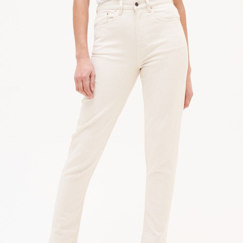 Eine Person trägt eine cremefarbene Hose mit hoher Taille und fünf Taschen vor einem weißen Hintergrund.