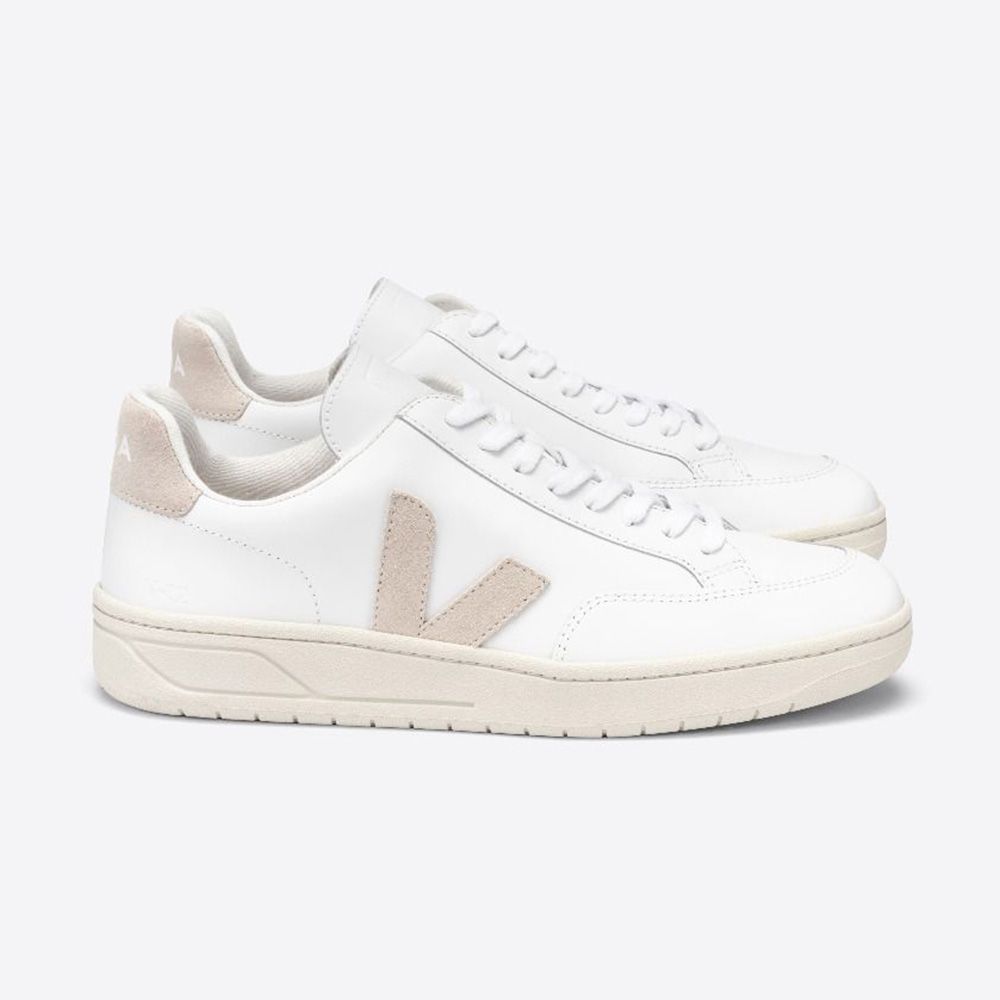 Weiße Sneaker mit beigem V-Logo und beigen Details an Ferse und Sohle, seitlich betrachtet.