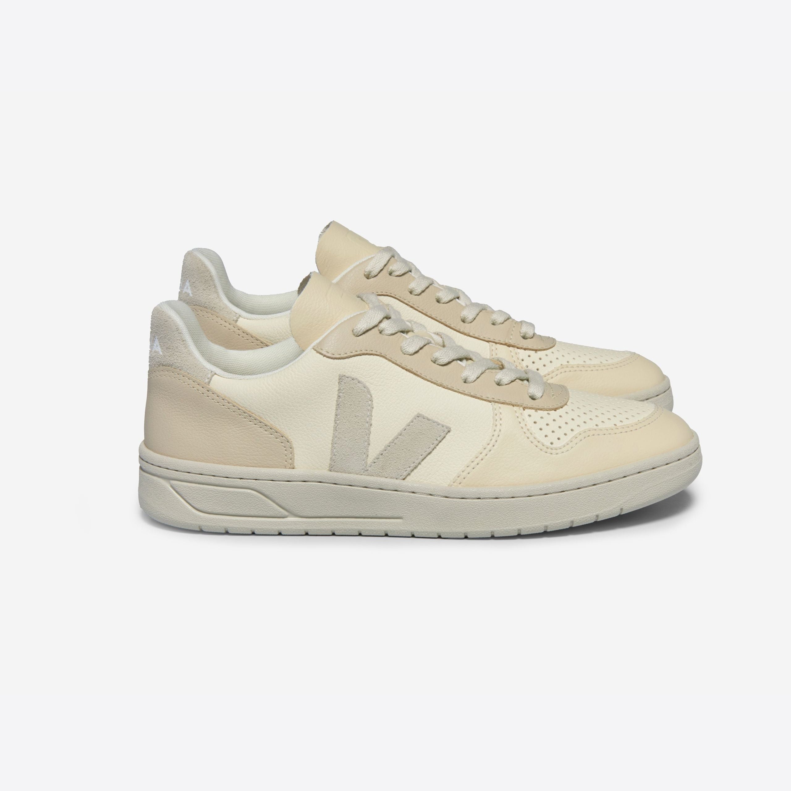 Beige Sneaker mit seitlichem V-Emblem auf weißem Hintergrund.