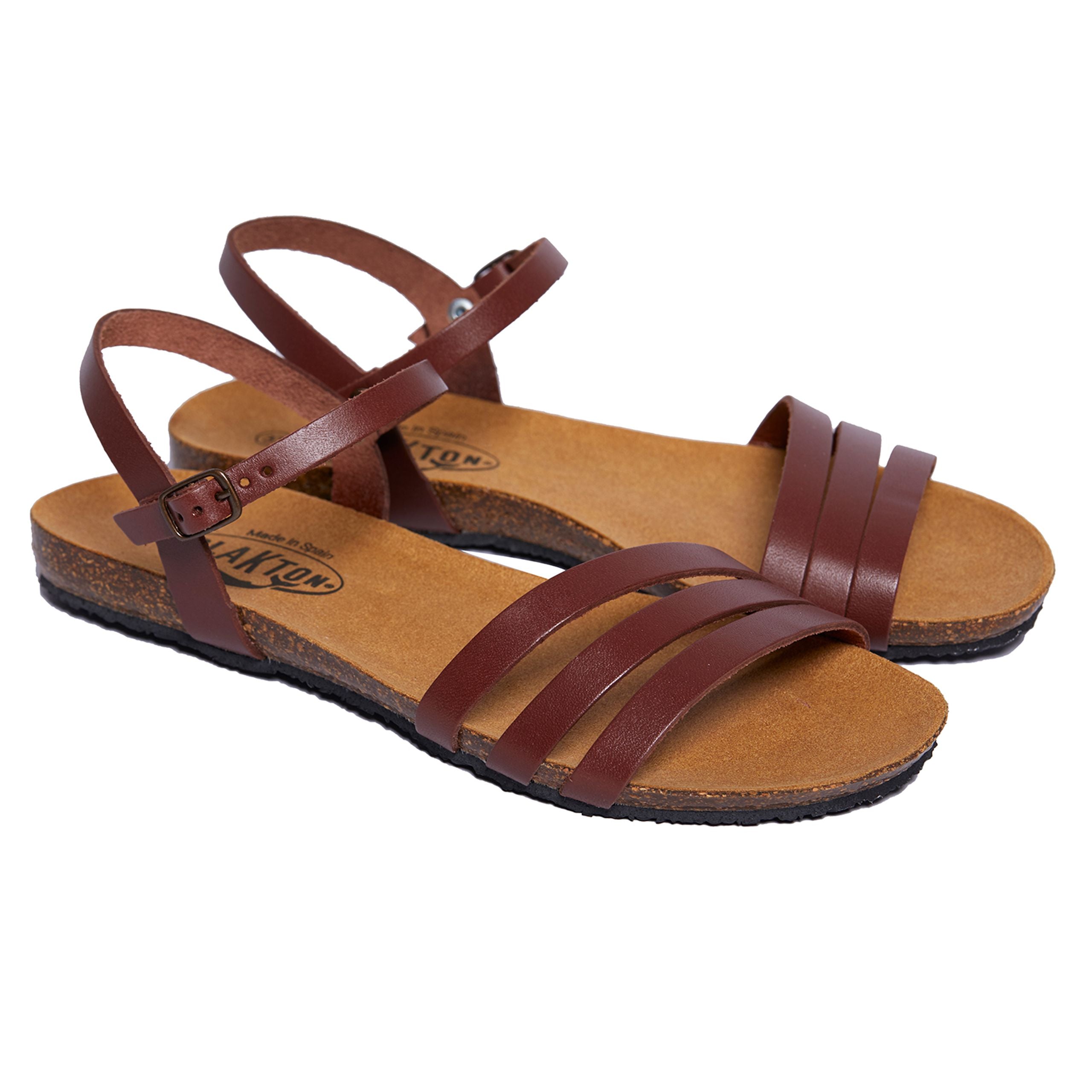 Braune Ledersandalen mit Riemen und Schnallenverschluss auf einer weißen Hintergrundfläche.