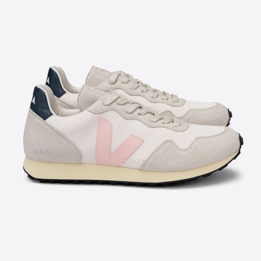 Zwei helle Sneakers mit rosa Details und dunklen Fersenverstärkungen auf weißem Hintergrund.