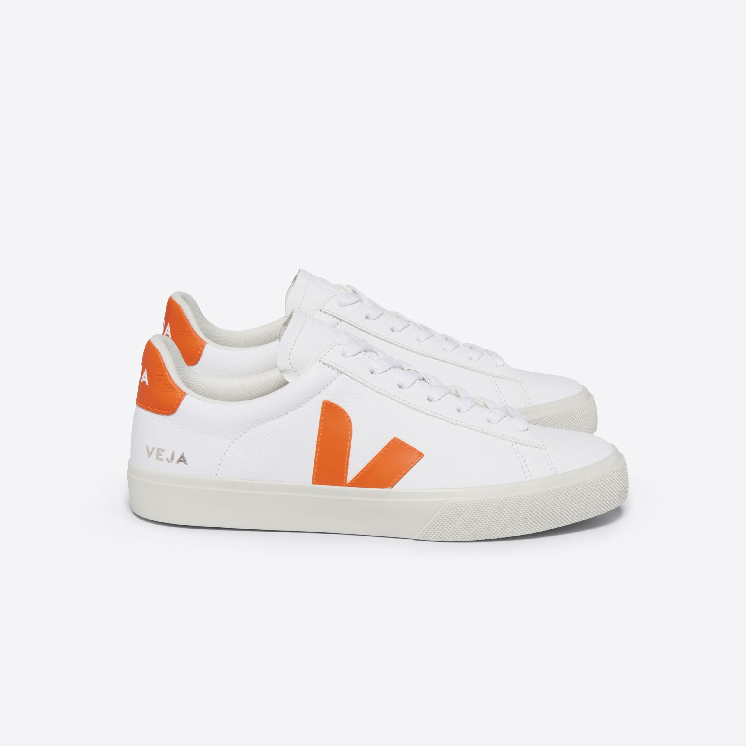 Ein Paar weiße Sneaker mit orangefarbenem Logo und Details.