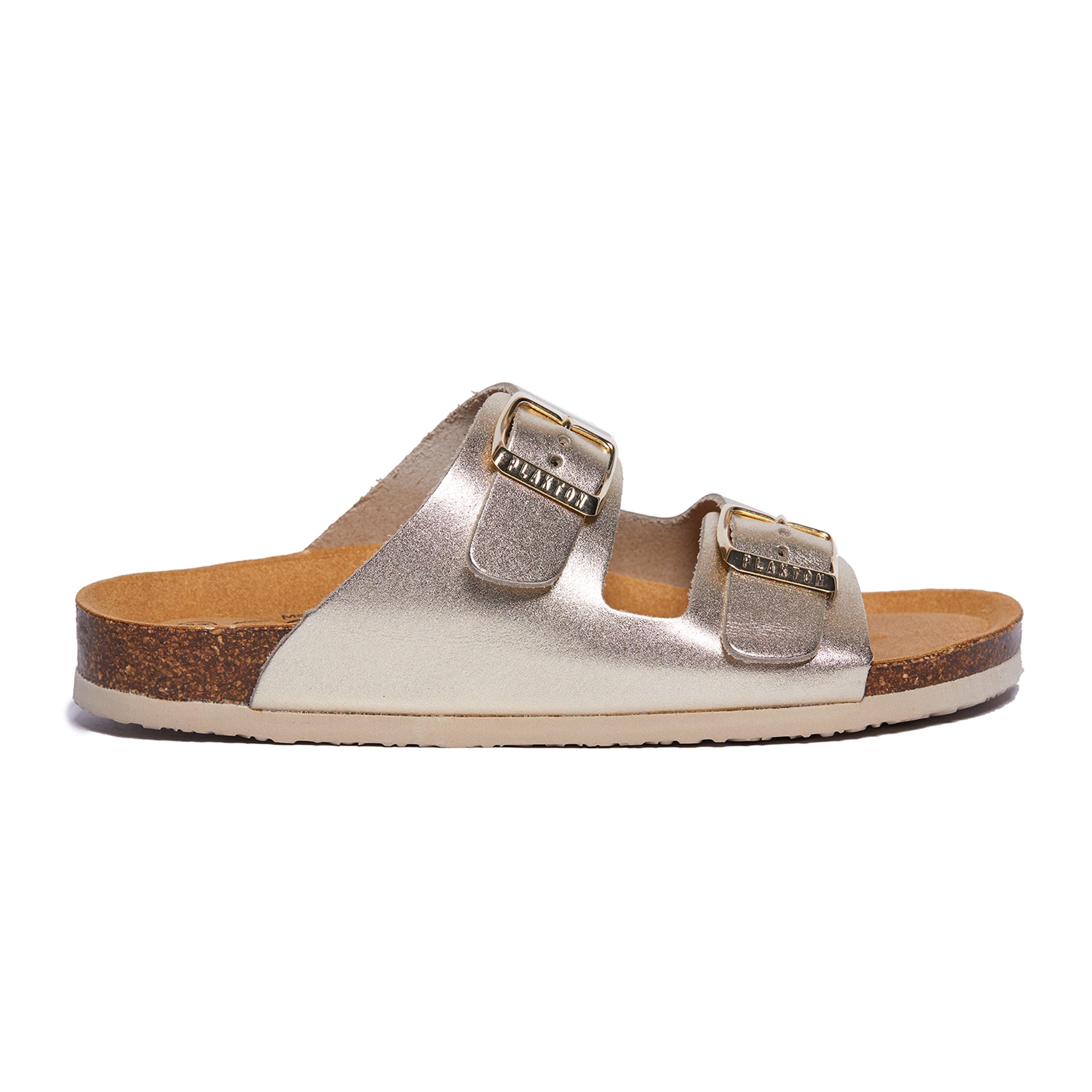 Goldfarbene Sandale mit zwei Schnallen und Korksohle, seitlich aufgenommen.