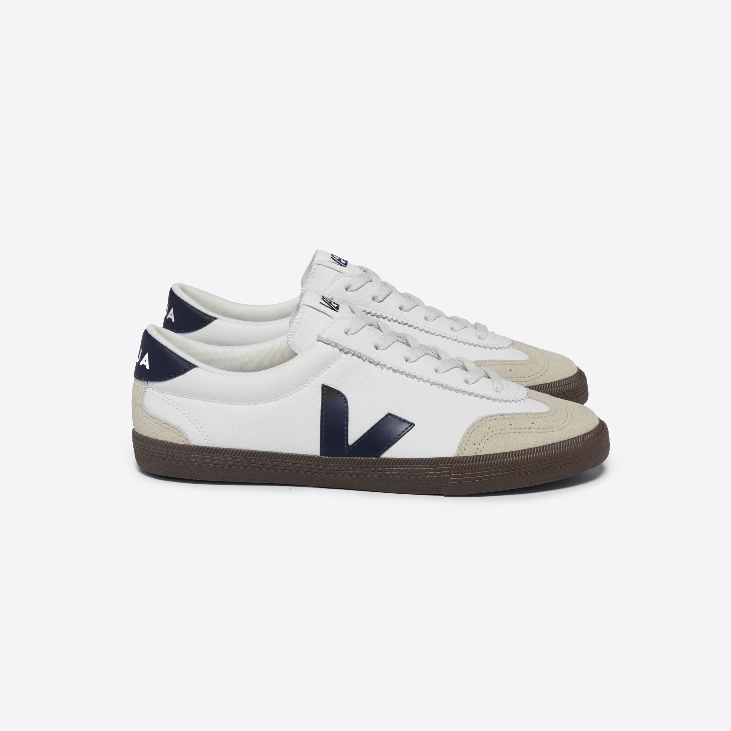 Weiße Sneaker mit dunkelblauem "V"-Logo, beigem Zehenbereich und dunkelbrauner Sohle, seitliche Ansicht.