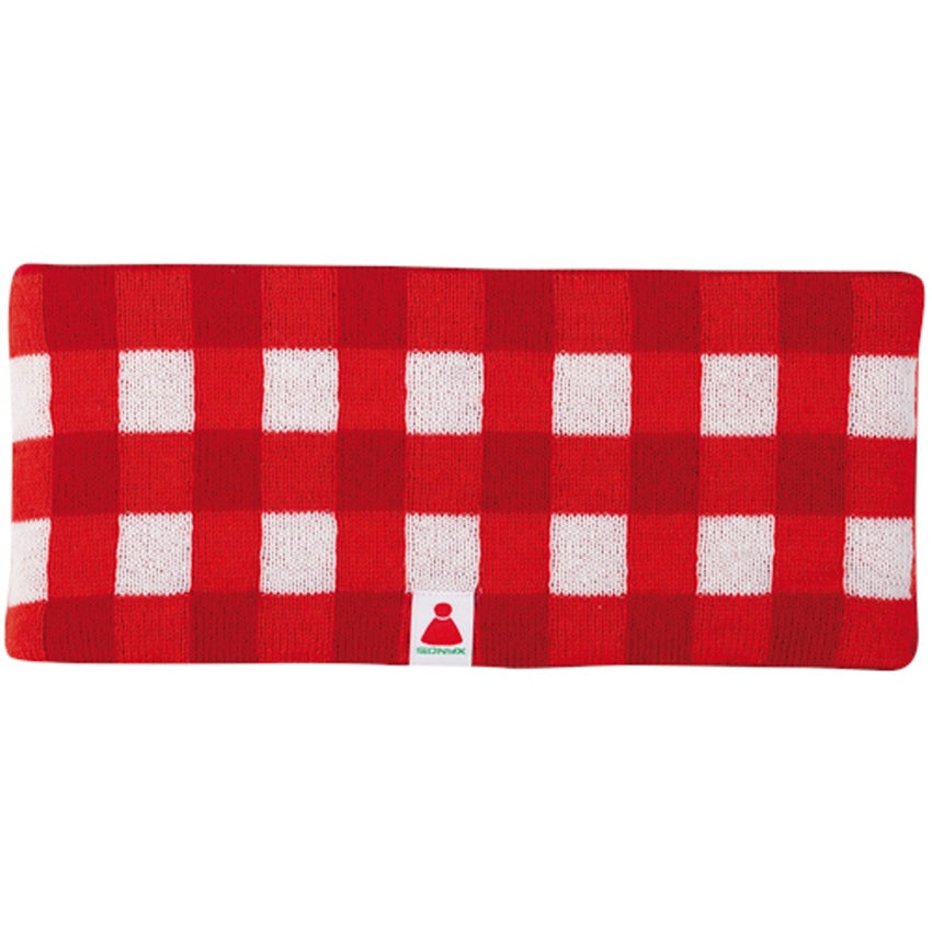 Ein rechteckiges, rot-weiß kariertes, gestricktes Stirnband mit einem kleinen Anhänger mit einem roten Symbol und grünem Text in der Mitte des unteren Randes.