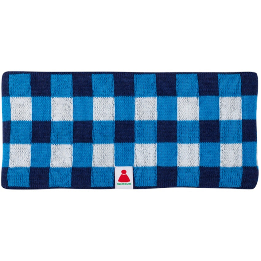 Ein rechteckiges, gestricktes Stirnband mit blauem, marineblauem und weißem Karomuster und einem kleinen Anhänger mit einem roten Symbol und grünen Details in der unteren Mitte.