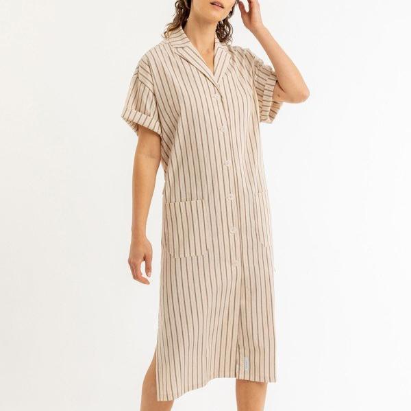 Person in a knee-length, short-sleeved striped dress touching their hair.