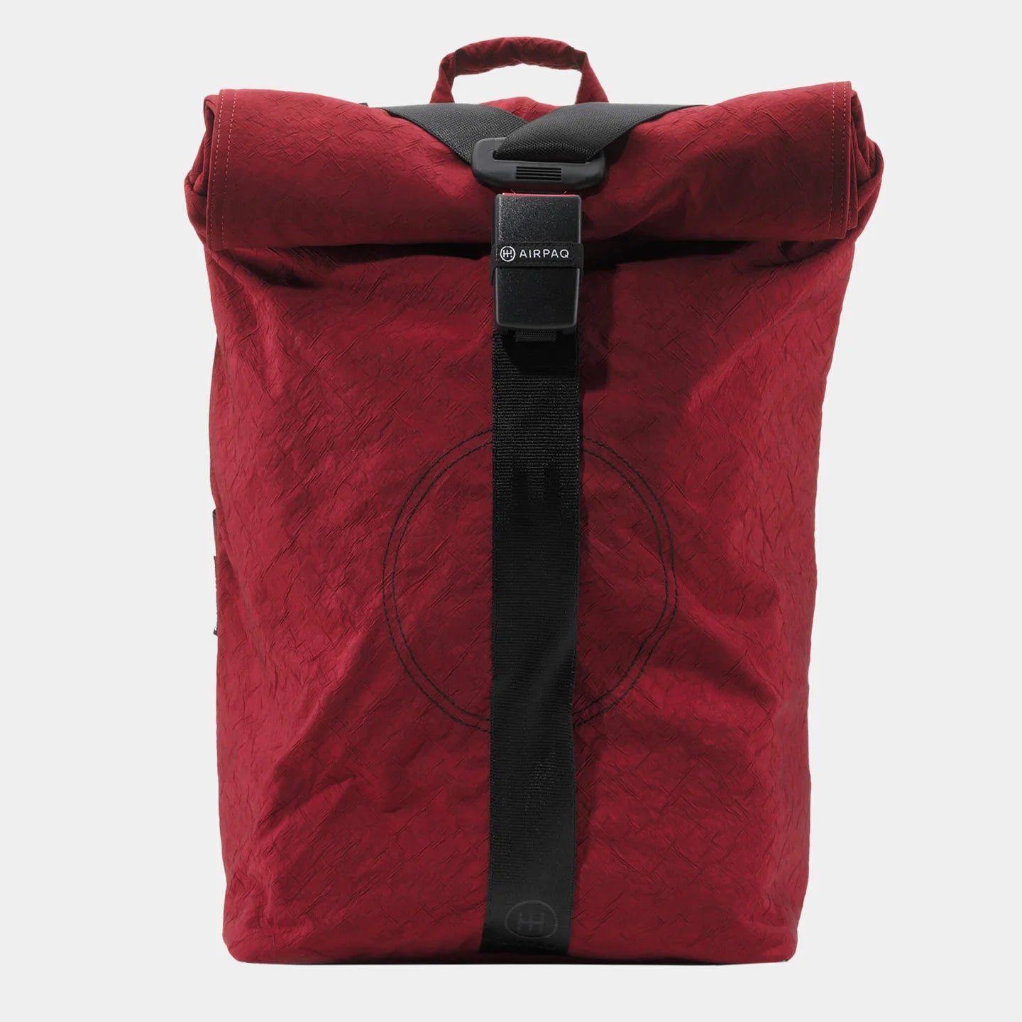 Roter Rucksack mit schwarzem Gurt und Verschluss, texturiertes Material, auf neutralem Hintergrund.